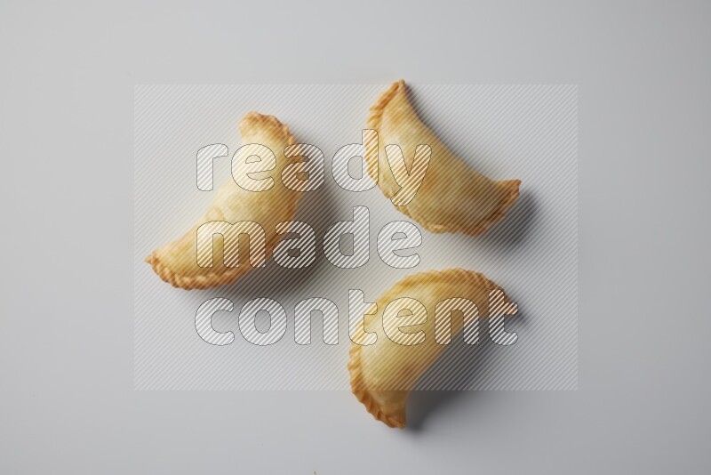 Three fried sambosa from a top angle on a white background