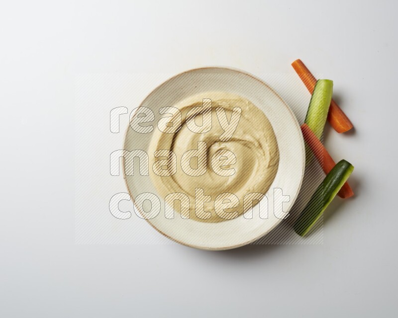plain Hummus in a pottry plate  on a white background