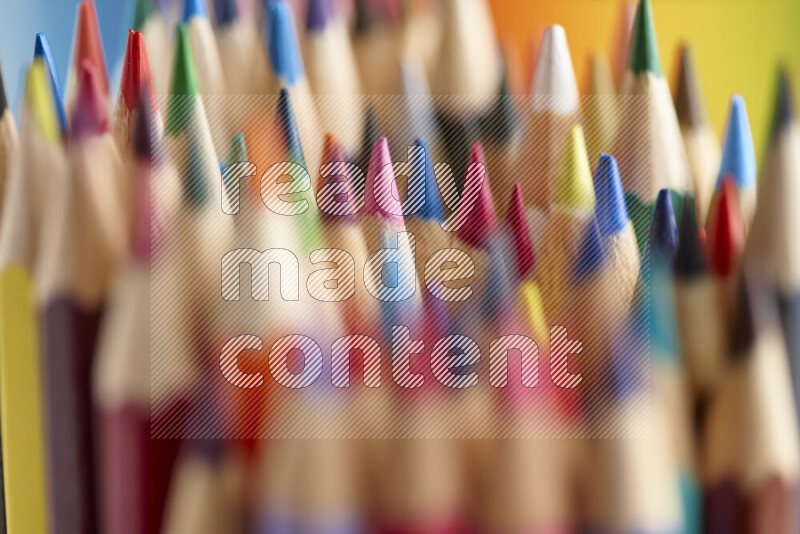 The image captures a close-up of sharpened colored pencils on multicolored background