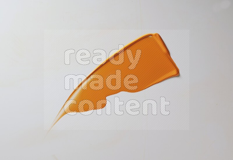 An orange single curved painting knife stroke on white background