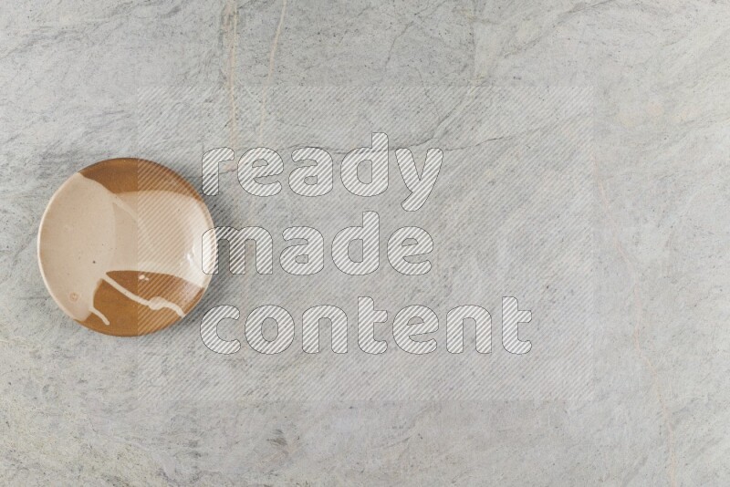 A multicolored pottery plate on grey marble background