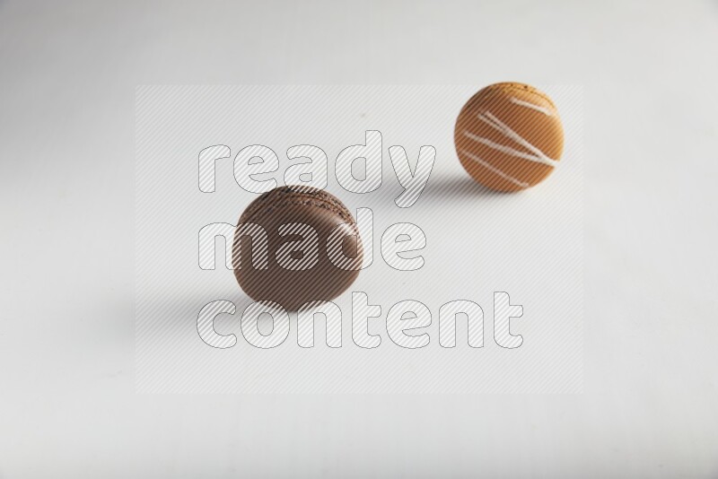 45º Shot of of two assorted Brown Irish Cream, and Brown Dark Chocolate macarons on white background