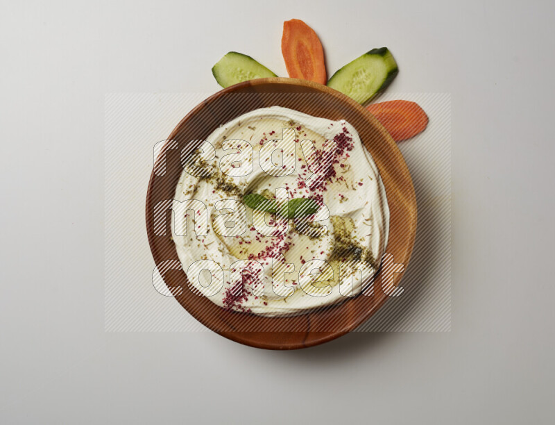 Lebnah garnished with  zattar , sumak & mint in a wooden plate on a white background