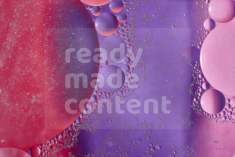 لقطات مقربة لفقاعات من الزيت على سطح الماء باللون الأحمر والأرجواني والوردي