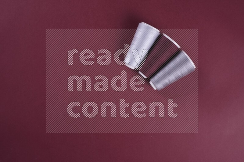 A grey collection of sewing and tailoring tools arranged on a red background