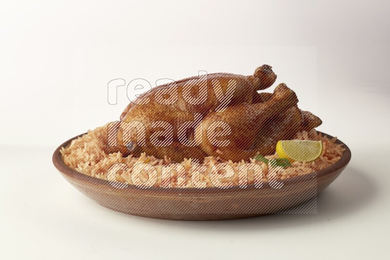 red basmati Rice with whole roasted chicken on a pottery plate direct on white background