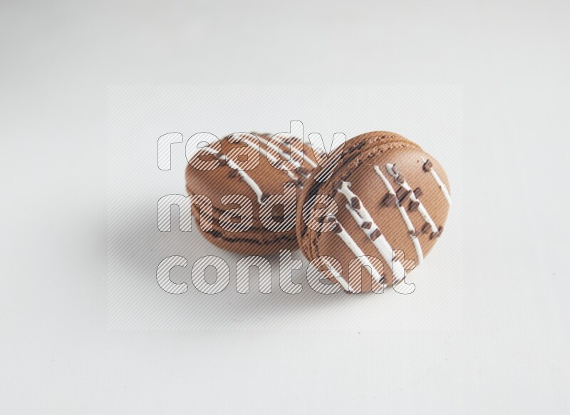 45º Shot of two Brown white Chocolate Caramel macarons on white background