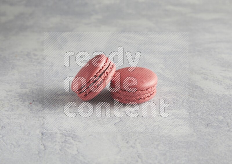 45º Shot of two Pink Raspberry macarons  on white  marble background