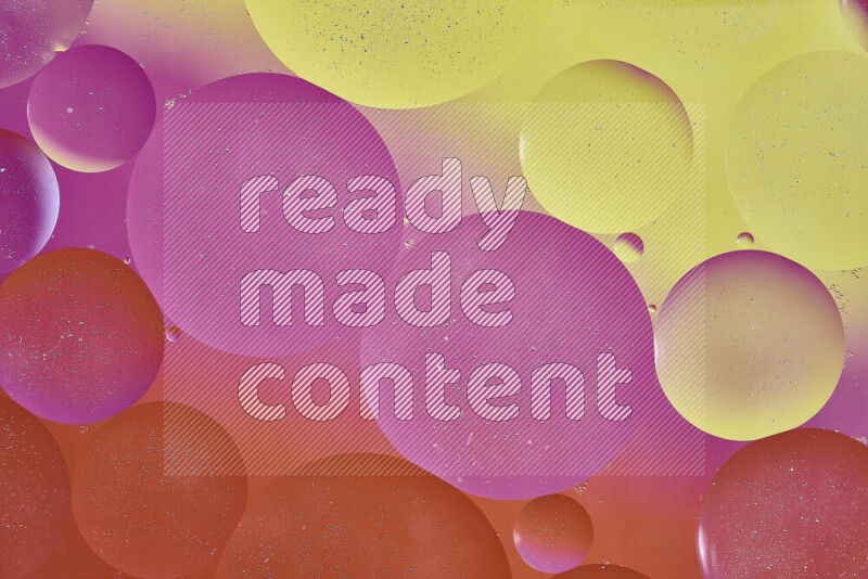 لقطات مقربة لفقاعات من الزيت على سطح الماء باللون الأصفر والبرتقالي والوردي