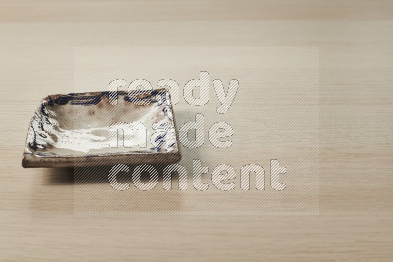 A decorative pottery plate on light wooden background