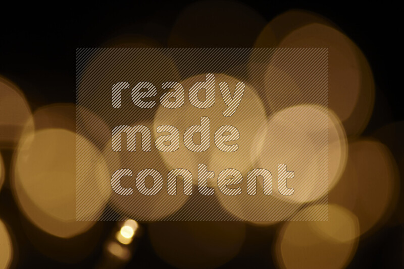 Light bulbs glowing against backdrop of golden bokeh