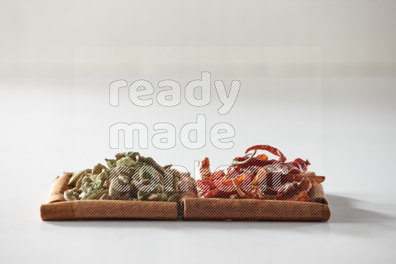 2 squares of cinnamon sticks full of cardamom and dried red chilis on white flooring