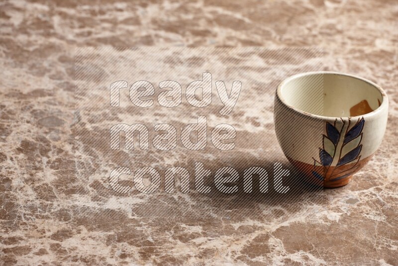A decorative pottery bowl on beige marble background