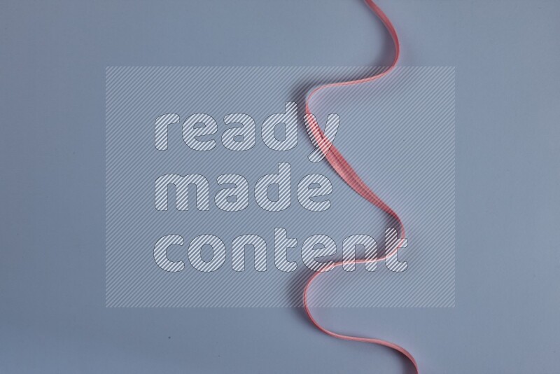 مجموعة من أدوات الخياطة والتفصيل زهرية اللون على خلفية زرقاء