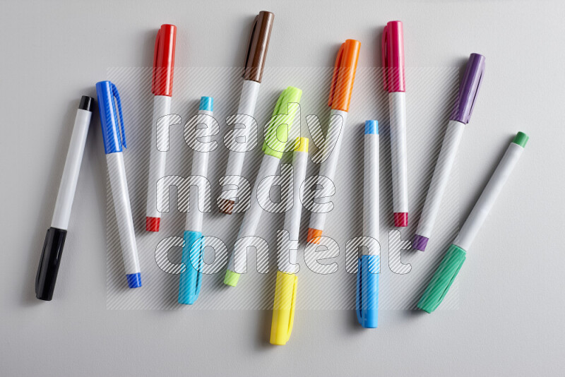 An arrangement of coloring pens in different colors on grey background