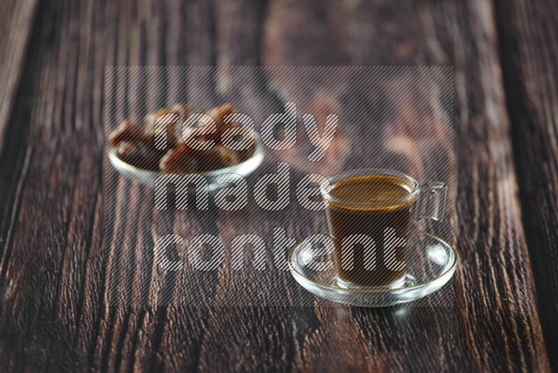 A coffee glass cup with dates and tea on wooden background