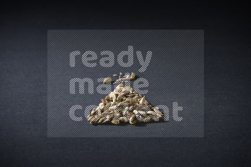 Cardamom in a triangle shape on black flooring