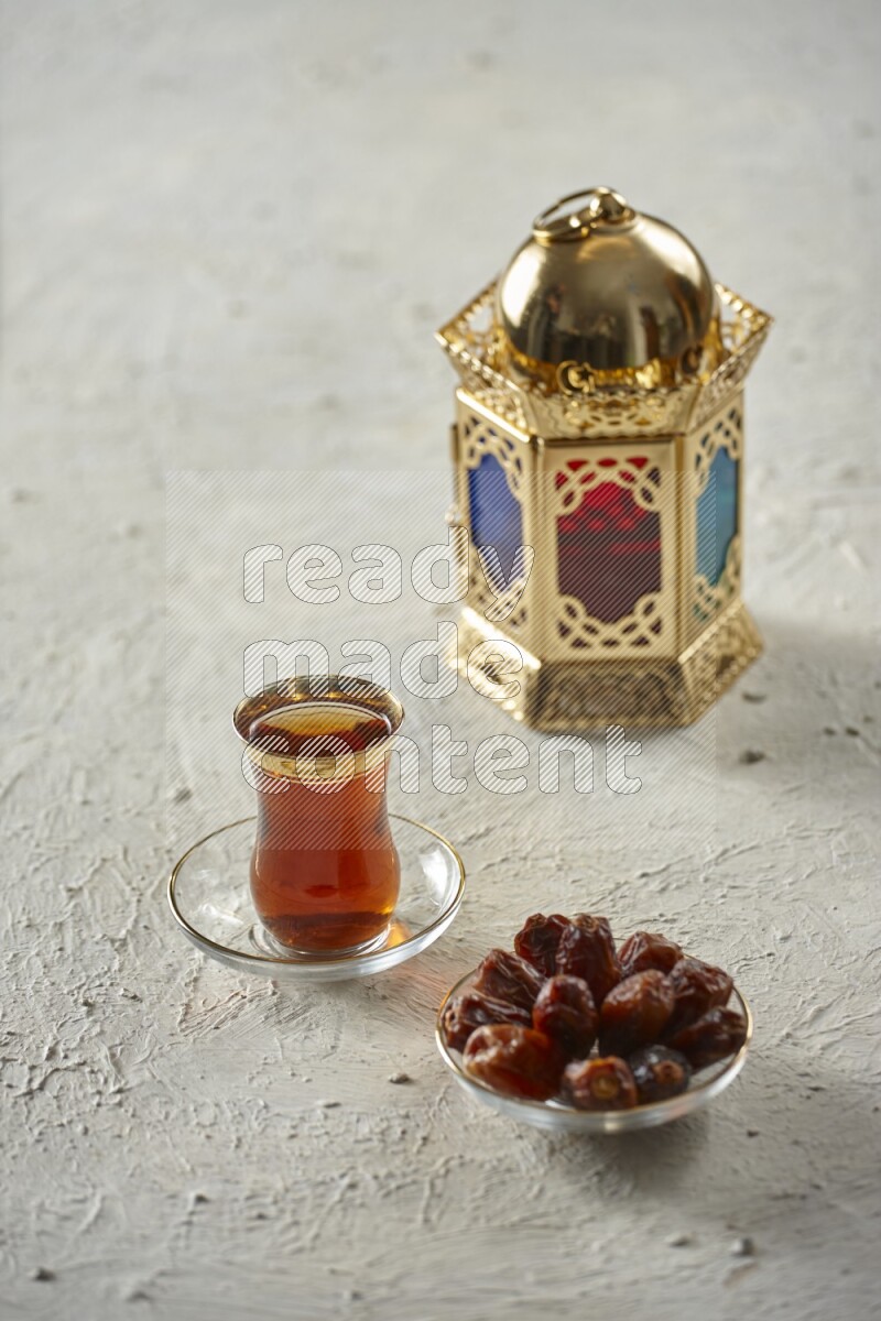 A golden lantern with different drinks, dates, nuts, prayer beads and quran on textured white background