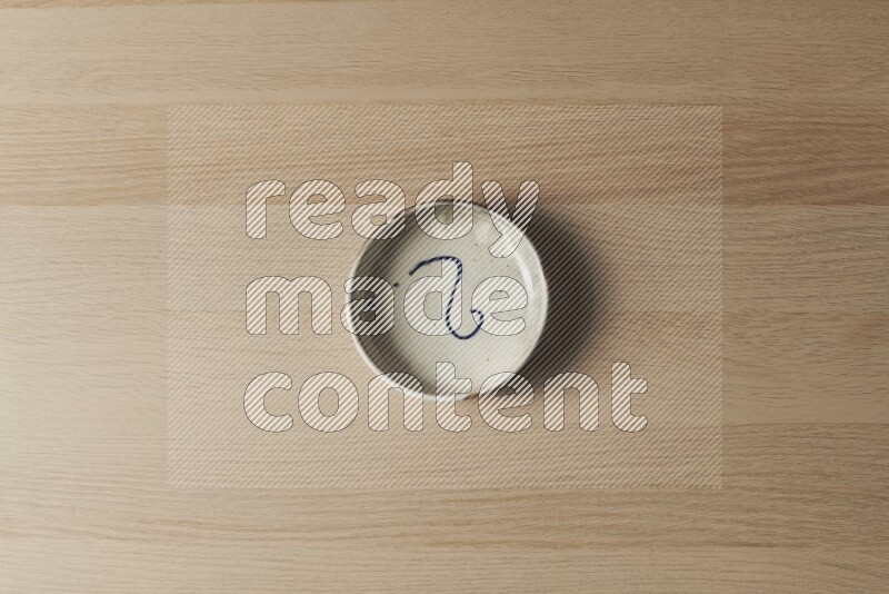 A multicolored pottery bowl on light wooden background