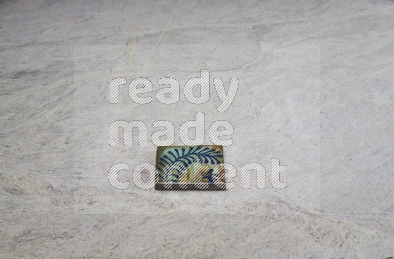 Top view shot of a pottery coaster\ tile on beige marble flooring