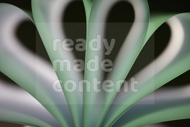 An abstract art piece displaying smooth curves in white and green gradients created by colored light