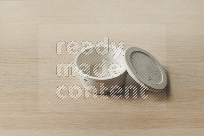 A white pottery bowl on light wooden background