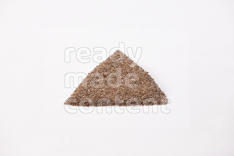 Flax seeds in a triangle shape on a white flooring