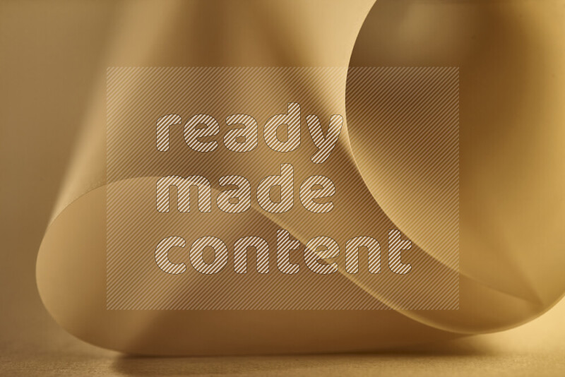 An abstract art piece displaying smooth curves in gold gradients created by colored light