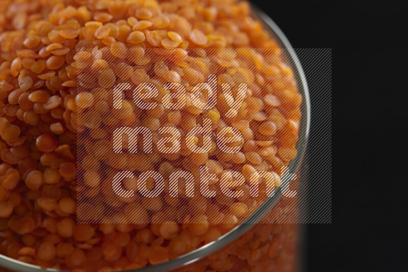 Lentils in a glass jar on black background