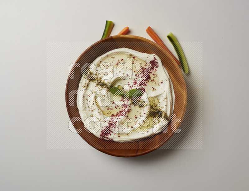 Lebnah garnished with  zattar , sumak & mint in a wooden plate on a white background