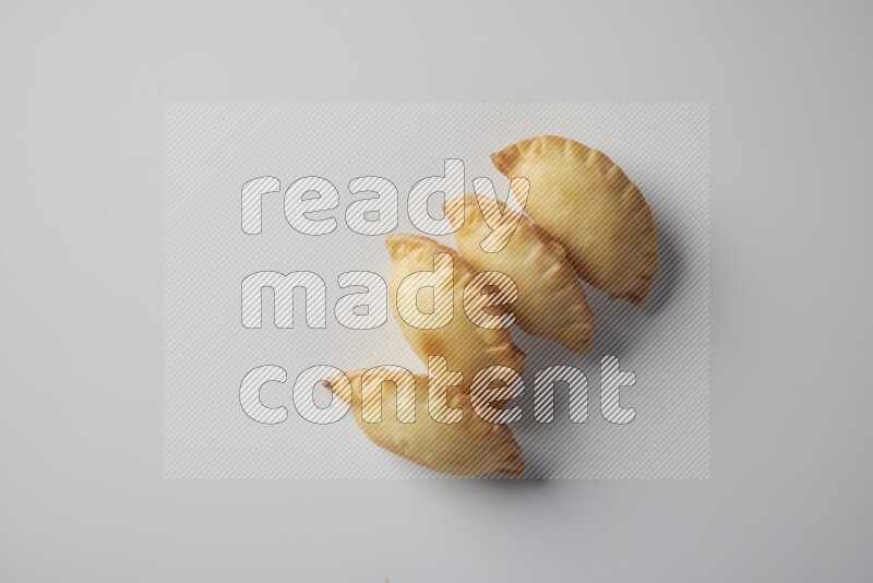 Four fried sambosa from a top angle on a white background