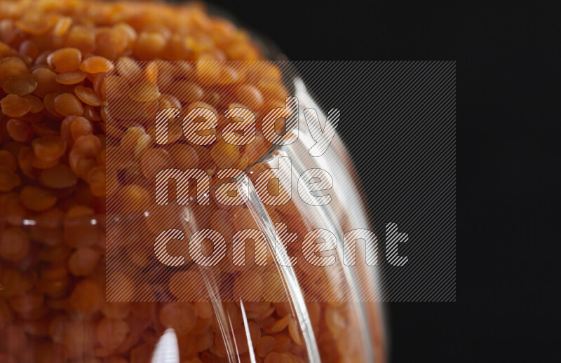 Lentils in a glass jar on black background