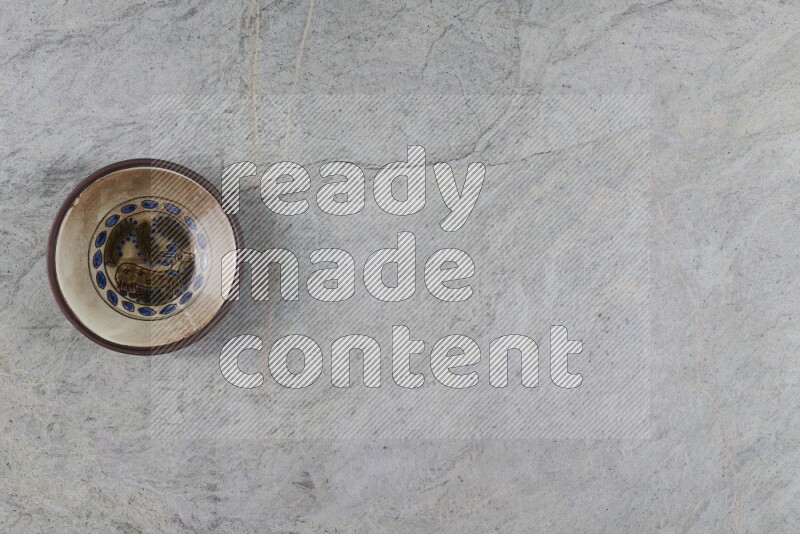 A decorative pottery plate on grey marble background