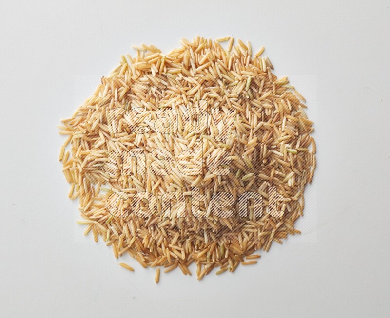 Top-view shot of long grain brown rice on white background