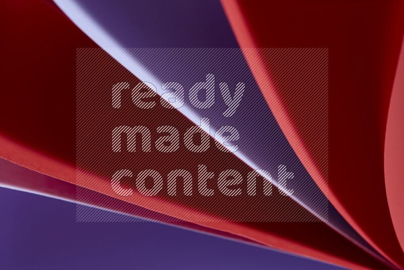 An abstract art showing purple and red paper sheets arranged in an overlapping curves