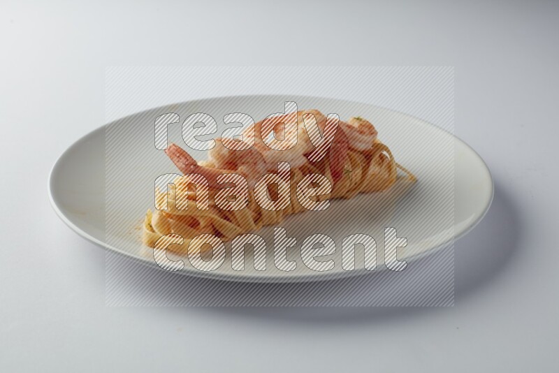 Fettuccini red sauce pasta with shrimp in a white plate on a white background