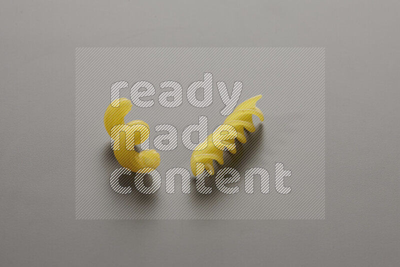Twist pasta with other types of pasta on grey background