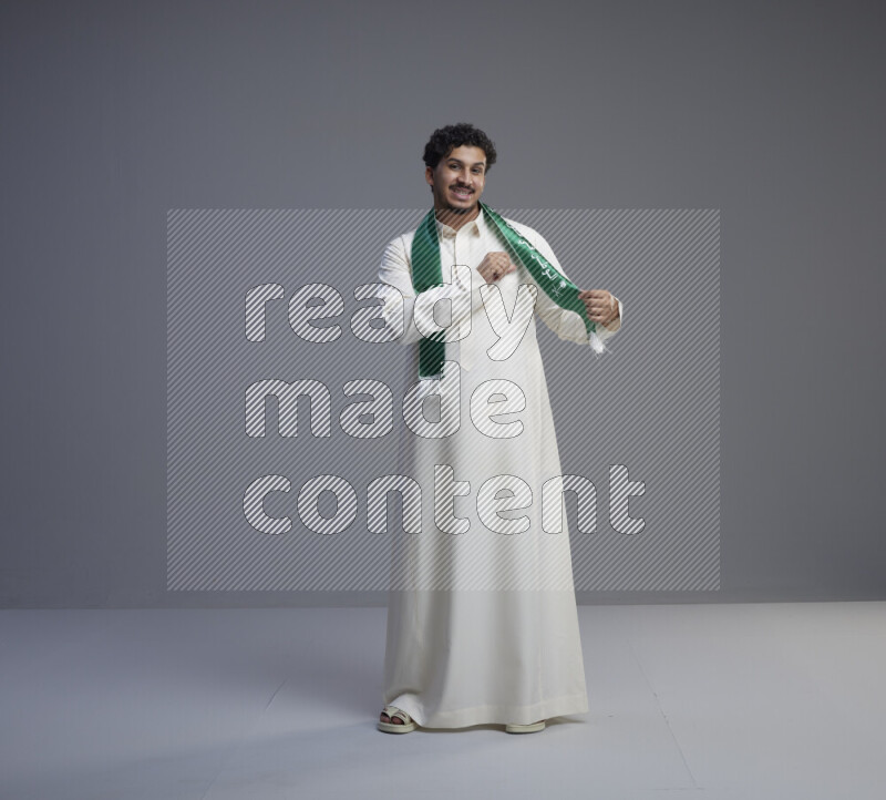 رجل سعودي يرتدي ثوب ابيض و شال يتفاعل مع الكاميرا