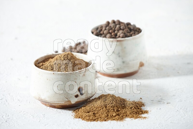 2 beige bowls, one full of powder and the other full of whole balls with balls and powder spreaded on a textured white flooring