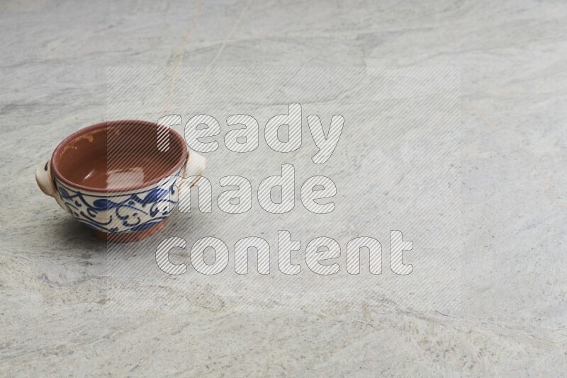 A multicolored pottery bowl on grey marble background