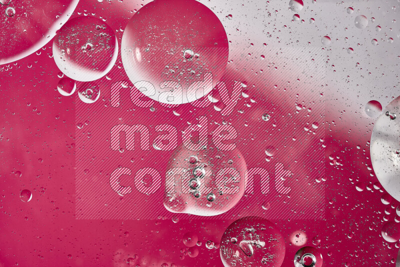 Close-ups of abstract oil bubbles on water surface in shades of white and pink