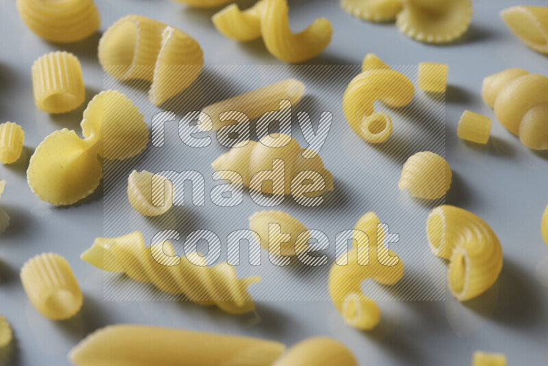 Different pasta types on light blue background