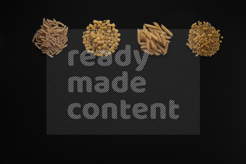 Different pasta types in 4 bunches on black background
