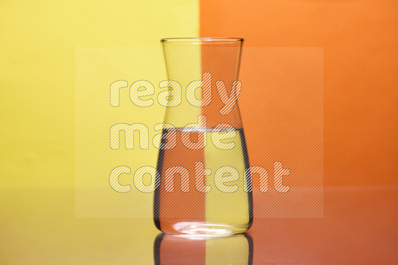 The image features a clear glassware filled with water, set against yellow and orange background