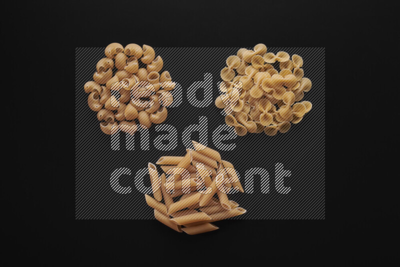Different pasta types in bunches on black background