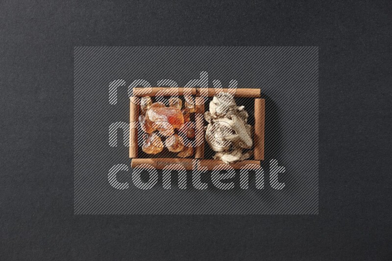 2 squares of cinnamon sticks full of dried ginger and gum arabic on black flooring