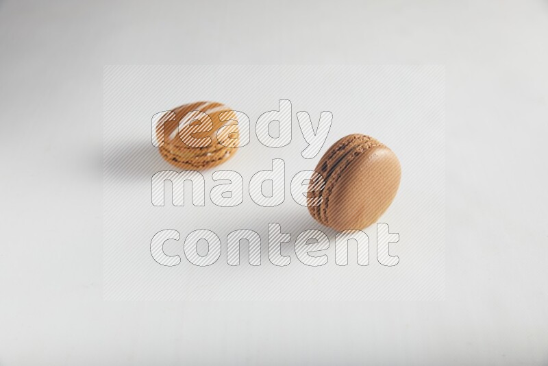 45º Shot of of two assorted Brown Irish Cream, and Brown Coffee macarons  on white background