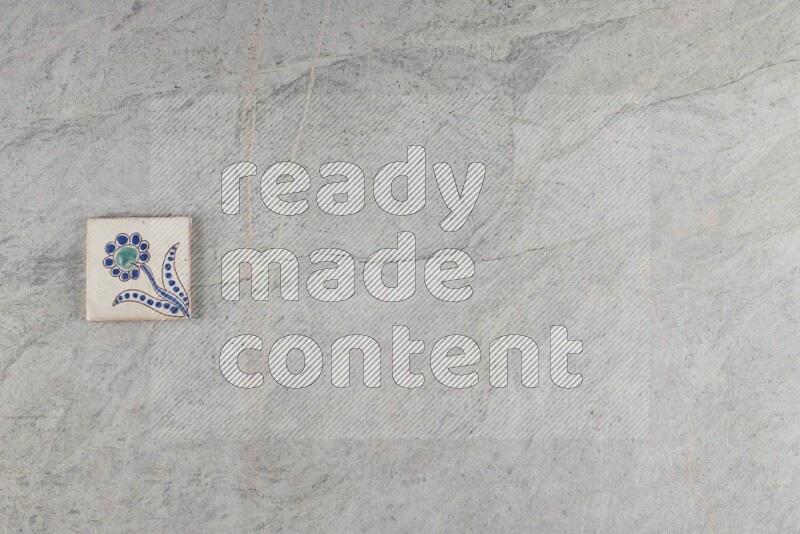 A decorative pottery coaster on grey marble background