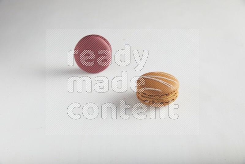 45º Shot of of two assorted Brown Irish Cream, and Red Cherry macarons on white background