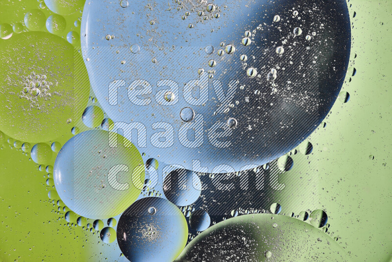 Close-ups of abstract oil bubbles on water surface in shades of green and blue